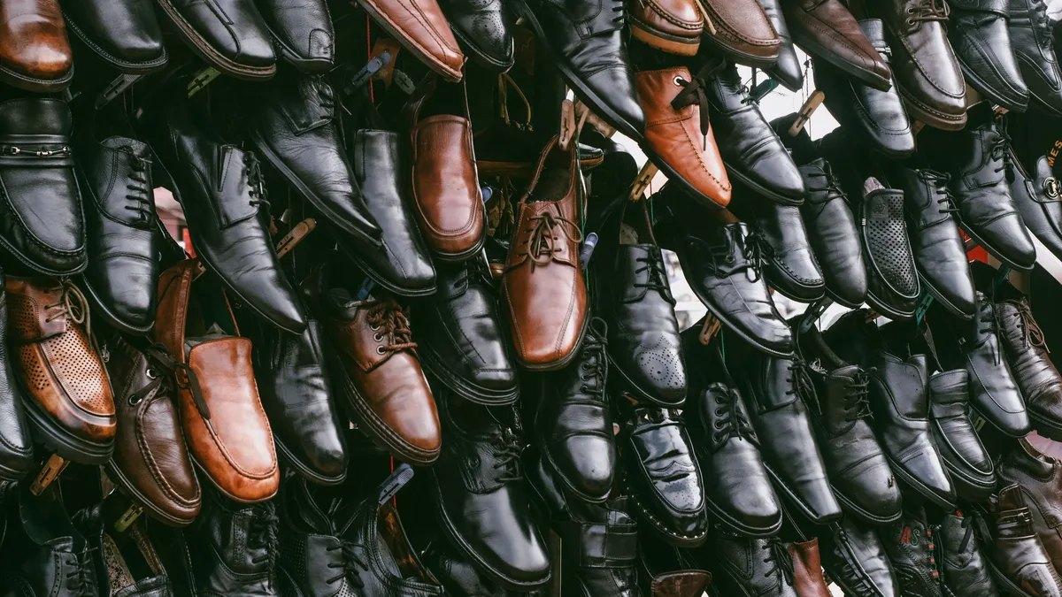 A large collection of men's dress shoes, including black and brown leather oxfords and lace-ups, arranged in a neat and organized manner.